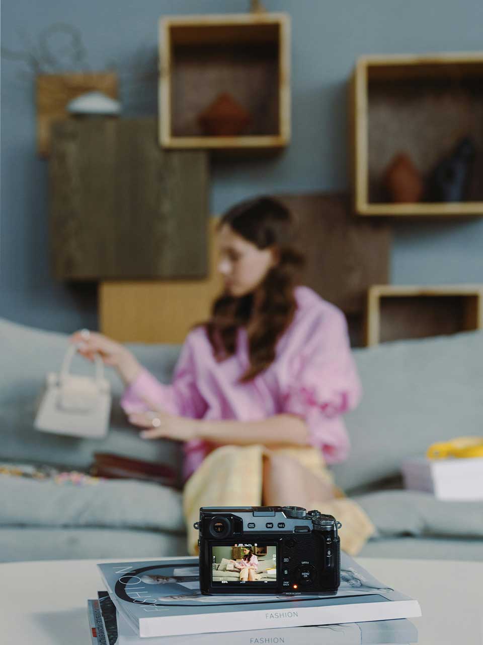 A photo of a Lady taking video of herself showing a hand bag