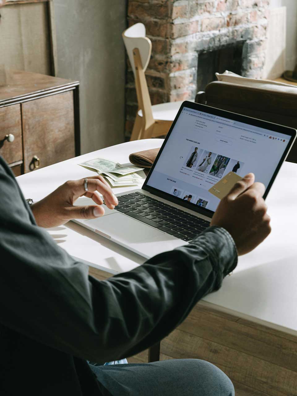 A man setting on a laptop with credit card in hand on the laptop an ecommerce website