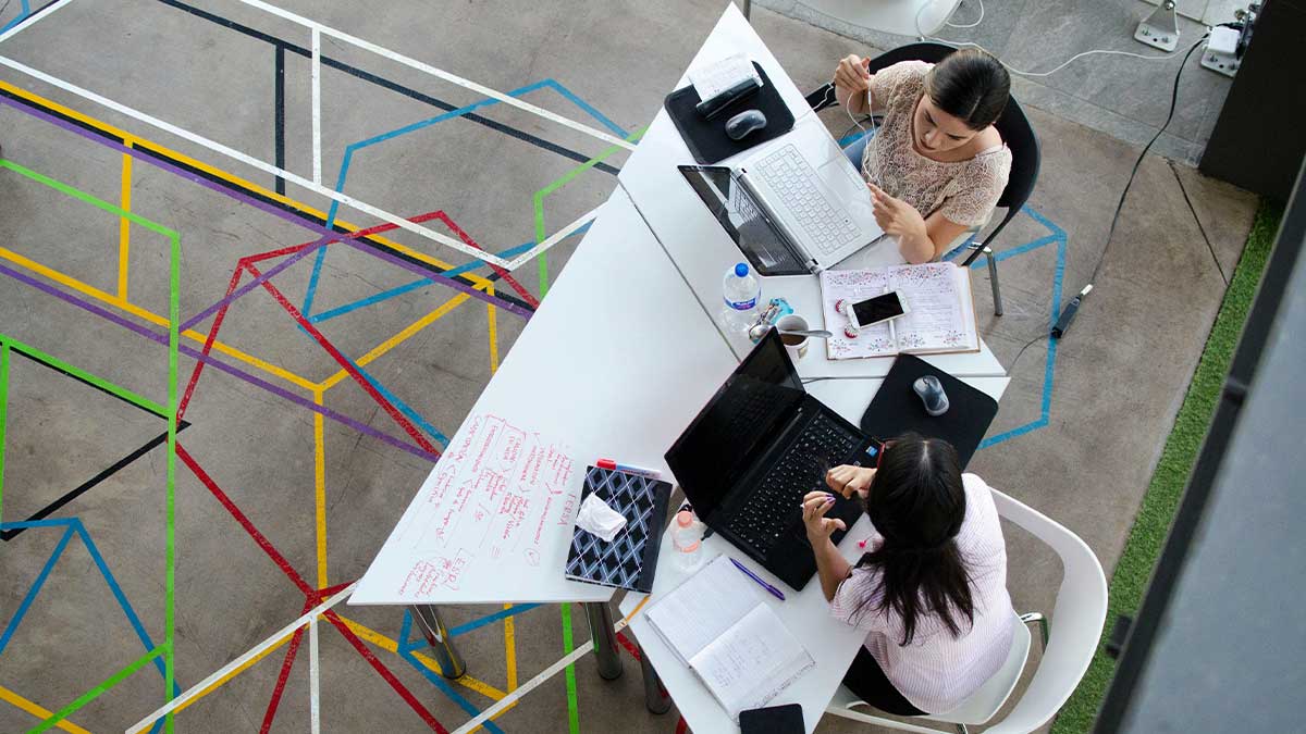 a photo of 2 women working on a strategy